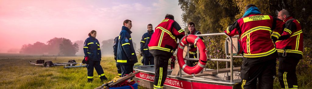 Feuerwehrleute auf einem Feld in der Dämmerung