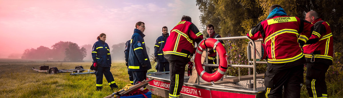 Feuerwehrleute auf einem Feld in der Dämmerung